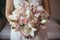 The bride holds a bouquet with lilies and roses