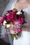 Bride holds a bouquet of peonies and hydrangeas