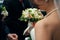 Bride holds a bouquet of white and green rose buds