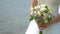 Bride holds bouquet of white and pink roses on flowing water background. Closeup of bouquet and hands. Moving frame