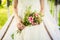 Bride holds bridal bouquet of pink flovers