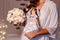 The bride holds a doll in a wedding dress and a bouquet