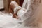 The bride holds in hand lose-up garter in hotel room. morning preparation wedding concept