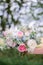 Bride holds rich wedding bouquet of pink and white peonies