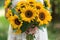 A bride holds a vibrant bouquet of sunflowers