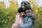 Bride in a knitted hat with a pom pom, hat covering her eyes. Groom in a colorful scarf. Wedding ceremony outdoors.