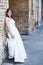 Bride leaning to brick wall