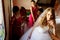 Bride leans on a handrail standing on the stairs while bridesmaids stand behind her