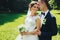 Bride leans to a groom standing with him in the garden