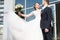 The bride lifts the bouquet up, a flying wedding dress, the groom smiles. Smiling young people of twenty-five years old, wedding