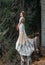 Bride in light chiffon wedding dress posing near the mountains