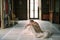 Bride in a long dress sits on the floor of an old villa with her head on her knees