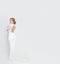 Bride in long white wedding dress on a white background. Luxurious dress in a woman`s body. The girl is preparing to marry