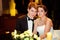 Bride looks joyful sitting with a groom at the table