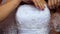 Bride in Low-cut Dress Arranges Top on Bust Closeup