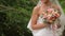 The bride is nervous before the wedding. Bride holding a perfume. nice wedding bouquet in bride`s hand. Bride is holding