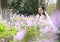 Bride portraint with white wedding dress in Orychophragmus violaceus flower field