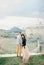 Bride put her head on the groom shoulder holding his hand on the ruins of the fortress