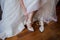 Bride puts shoes on her feet