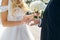 The bride puts a wedding ring on the groom finger, a beautiful wedding ceremony with fresh flowers, a beautiful girl and a
