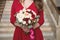 Bride in a red dress. Bridesmaid in a red dress. Wedding bouquet with a red ribbon