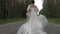 The bride runs along the road and her dress develops