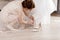 The bride`s feets. The girlfriend of the bride is putting her shoes on the bride`s feet. White pantyhose. Wedding Shoes