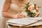 Bride`s hand puts signature pen on consent to marry at wedding close-up