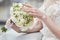 bride\'s hands adjust the white flowers in the bridal bouquet. close-up  blurred background  no face