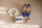 The bride`s wedding accessories are white and blue: shoes, ring cushion, perfume, garter and earrings