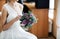 Bride sitting and holding bouquet