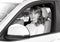 Bride sitting in white car, monochrome photo