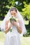 Bride smelling fresh flowers in garden