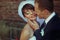 Bride smiles with closed eyes while groom touches her face delicately