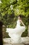 Bride spinning in a white dress on the bank of the lake