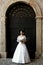 Bride standing in front of a black arch gate.