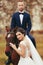 Bride stands behind a horse while groom sits on its back