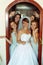 Bride stands in doors surrounded by bridesmaids