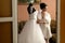 The bride stands near wedding dress in the room
