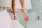 Bride takes her dress from the cornice. Wedding. Slender legs of a beautiful girl