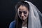 Bride with tear-stained face on black background