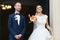 Bride throws sweets standing with a groom in the church entrance