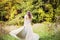 Bride twirling wedding dress in forest