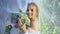 Bride under veil with bouquet of flowers walks in Park.