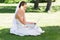 Bride using laptop and mobile phone in park
