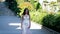 Bride walking along alley wearing beautiful wedding dress