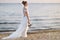 Bride walking along sea coast in wedding dress