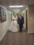Bride walking through a hall with her brother under the lights