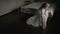 The bride wears a Shoe sitting on the bed in a wedding dress. General plan