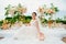 bride in the wedding ceremony area of live white and pink flowers.